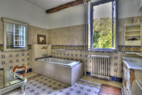 une salle de bain avec une baignoire, un lavabo et une fenêtre dans l'établissement Château De Blavou Normandie, à Saint-Denis-sur-Huisne