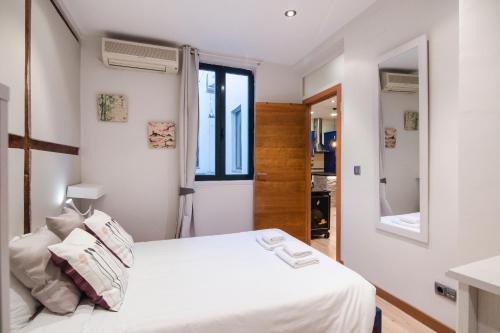a bedroom with a white bed and a window at San vicente Ferrer 22 in Madrid