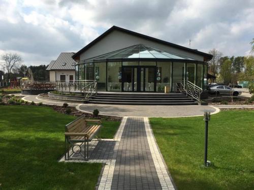 a building with a bench in the grass at Hotel KARO in Radom