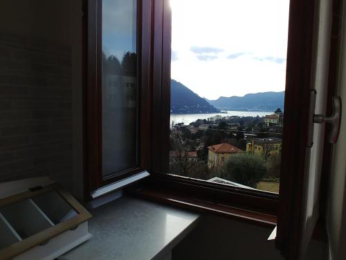 a window with a view of a city at La Finestra Sul Lago in Cernobbio