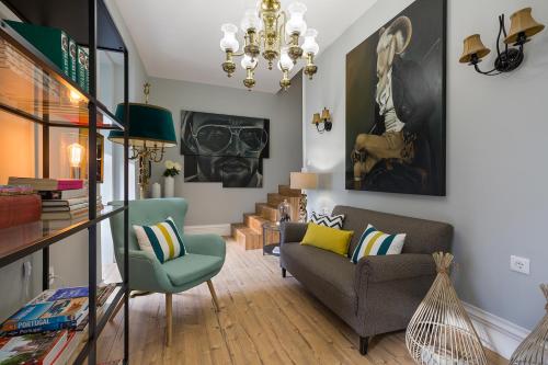 un soggiorno con divano, sedie e lampadario pendente di the gallery Studios II a Porto
