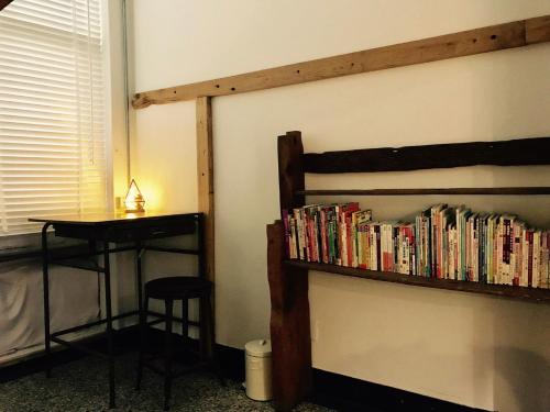 a book shelf filled with books next to a table at Cao Ji Book Inn Hostel in Tainan