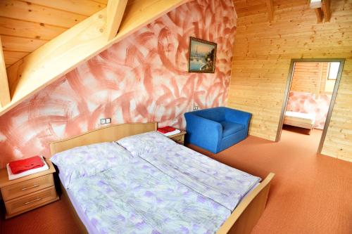 a bedroom with a bed and a blue chair at Resort Hulín in Sedlčany