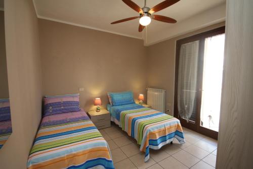 a bedroom with two beds and a ceiling fan at Universal Apartments Itri C in Itri