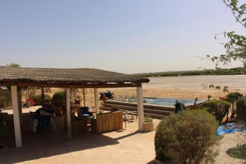 a gazebo on the beach next to a beach at Hôtel Les Cordons Bleus in Ndangane