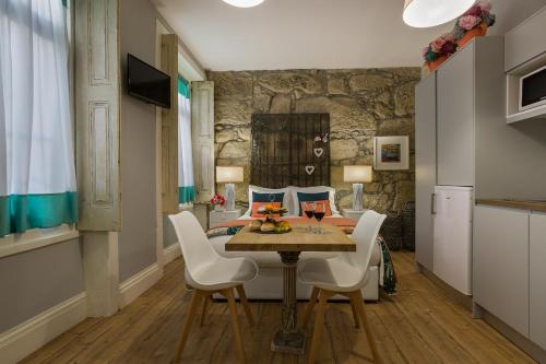 a dining room with a table and white chairs at the gallery Studios II in Porto