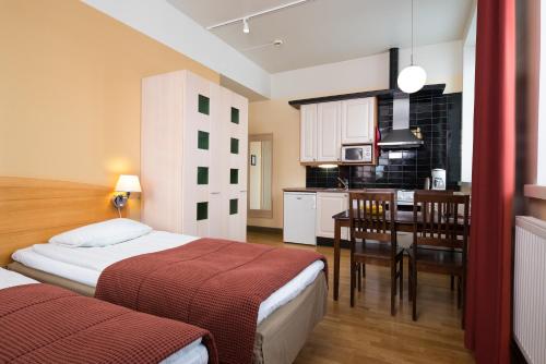 タンペレにあるホテッリ ヴィルのベッド2台とキッチンが備わるホテルルームです。