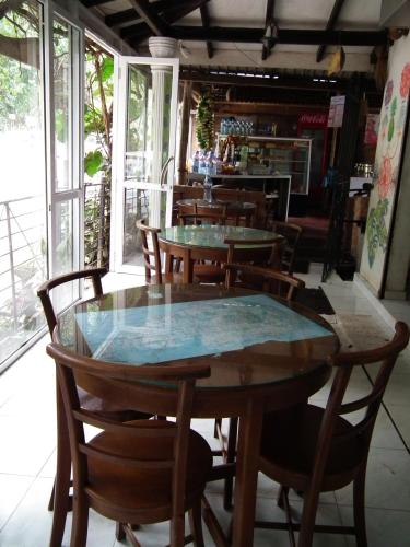 a table and chairs in a room with windows at Deniyaya National backpackers hostel in Deniyaya