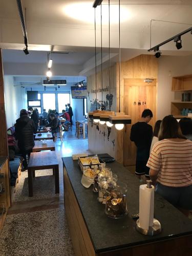 a group of people in a kitchen with a counter at Cao Ji Book Inn Hostel in Tainan