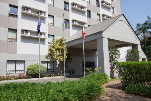a building with two flags in front of it at Comfort Hotel Joinville in Joinville