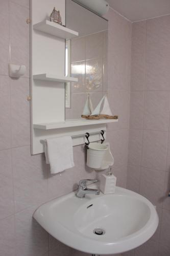 a white bathroom with a sink and a mirror at Remvi Studios in Pounda