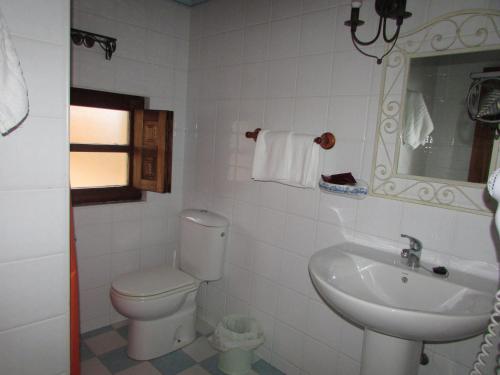 a white bathroom with a toilet and a sink at Posada rural el rincón de Cabrojo in Cabrojo