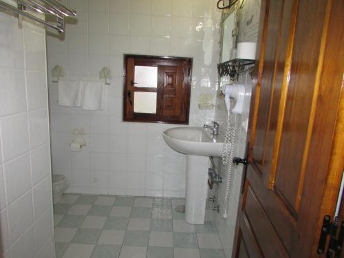 a white bathroom with a sink and a mirror at Posada rural el rincón de Cabrojo in Cabrojo