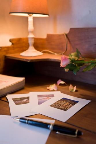 a desk with a pen and papers on a table with a lamp at Chez l'Autre in Chilhac