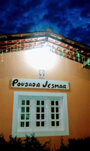 a sign on the side of a building with a window at Pousada Jesmar in Praia do Frances