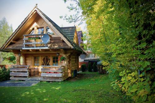una pequeña casa de madera con porche y patio en Klimkówka, en Zakopane