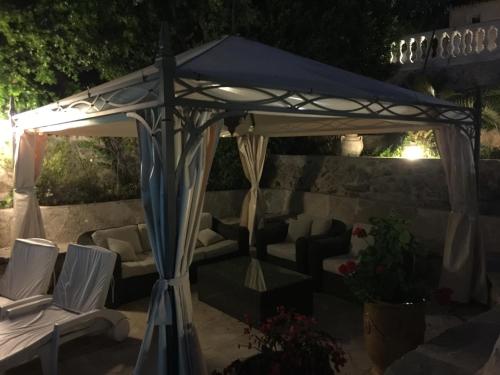 a gazebo with couches and chairs under it at La Bergerie B&B in Vence