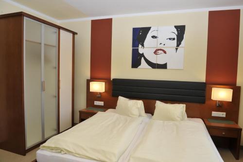 a bedroom with a bed with a painting on the wall at Villa Castelli in Schladming