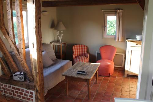 a living room with a couch and a table at La Bouillerie du Clos in Branville