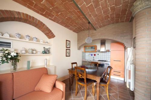 a kitchen and dining room with a couch and a table at Villa il Pino by VacaVilla in Lari