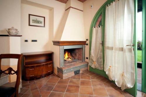 a living room with a fireplace and a window at Villa il Pino by VacaVilla in Lari