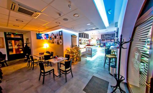 a restaurant with tables and chairs in a room at CVSE Clubház és Panzió in Cegléd