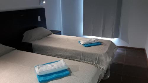 two beds with towels on top of them in a room at Akun Hotel in Santa Clara del Mar