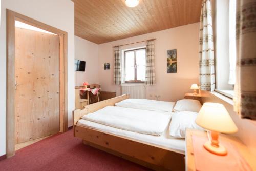 a bedroom with a bed and a window at Landgasthof Pilsenhof Entenbraterei in Hechendorf am Pilsensee