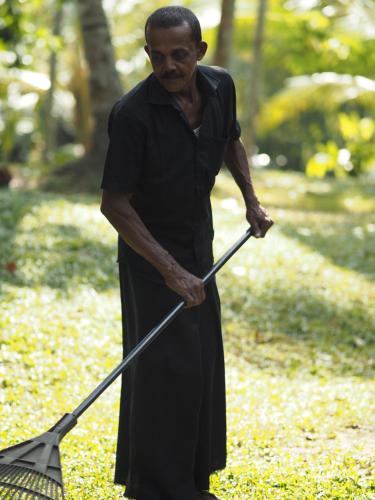 a man holding an umbrella in a park at KAJU GREEN eco lodges in Unawatuna