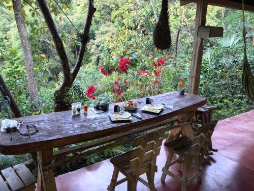 une table en bois avec de la nourriture dessus sur une terrasse dans l'établissement Finca San Rafael - Cafe y Cacao, à Minca