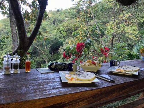 Finca San Rafael - Cafe y Cacao في مينسا: طاولة خشبية عليها صحون طعام