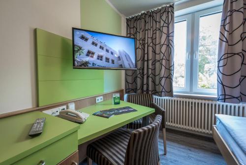 a hotel room with a desk and a phone at Kloster Neustadt in Neustadt an der Weinstraße