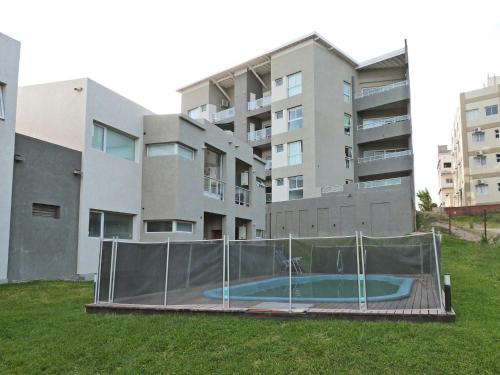 Departamentos Valeria Medanos في فاليريا ديل مار: مبنى فيه طوق لكرة السلة امام مبنى