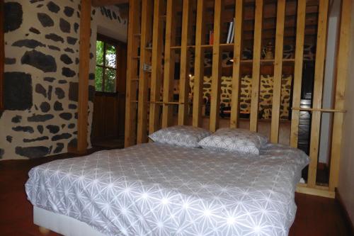 1 dormitorio con 1 cama en una habitación con paredes de madera en La Loge en Sanssac-lʼÉglise