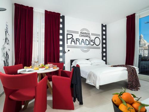 a bedroom with a bed and a table and chairs at Duomo Suites & Spa in Catania
