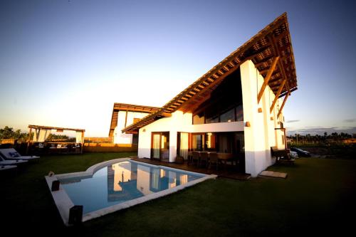 una casa con piscina frente a ella en Mencey Loco Beach House, en São Miguel do Gostoso