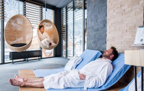 a man laying in a bed in a room at Alpina Eclectic Hotel in Chamonix-Mont-Blanc