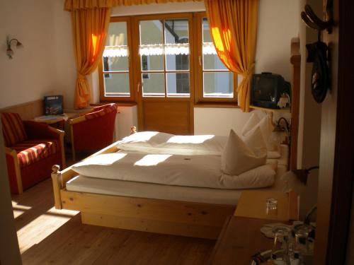 a bedroom with a large bed with a window at Landhaus Lenzenhof in Reit im Winkl