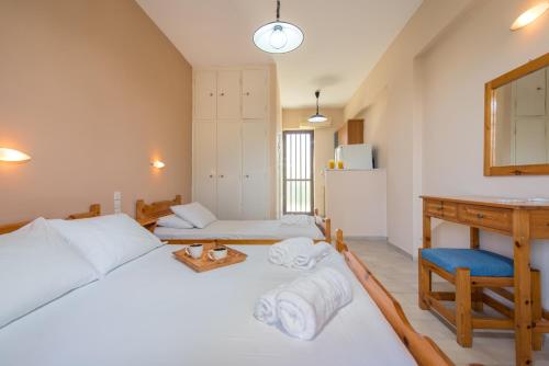 a bedroom with a bed and a sink and a refrigerator at Helen & Theo Studios in Laganas