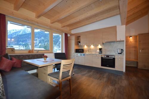 a kitchen with a table and a kitchen with mountains at Apartments & Zimmer Urschnerhof in Pertisau