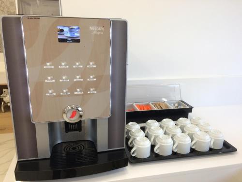 a coffee maker with a tray of white cups at Harma Boutique Hotel in Hersonissos