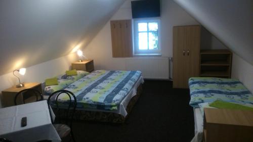 1 dormitorio con 2 camas y ventana en Penzion U pily, en Paseky nad Jizerou