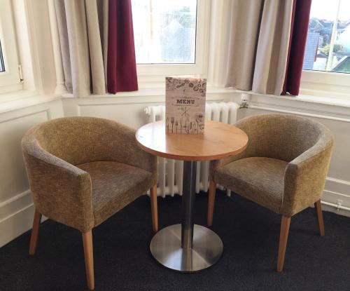 a table with two chairs and a table with a box on it at Stotfield Hotel in Lossiemouth
