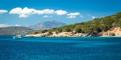 a boat in a large body of water at Gabbiano Azzurro Hotel & Suites in Golfo Aranci