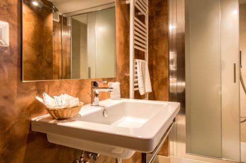 La salle de bains est pourvue d'un lavabo blanc et d'un miroir. dans l'établissement Casa Santo Nome di Gesu, à Florence
