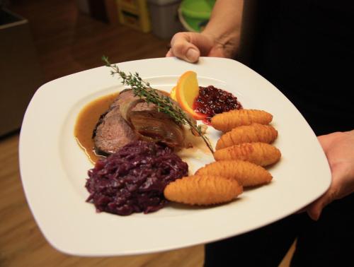 a plate of food with meat and vegetables on it at Gasthof Pension Zoller in Wolfsberg
