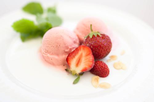 a plate of ice cream with strawberries and nuts at Gasthof Pension Zoller in Wolfsberg