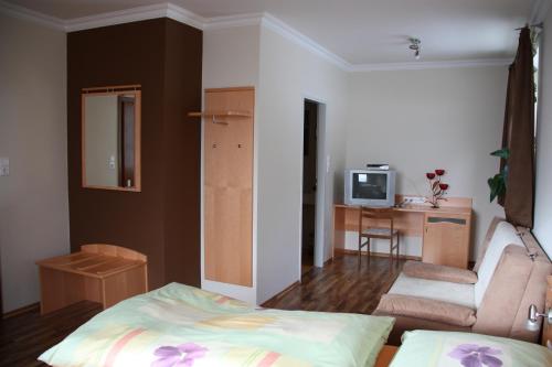a bedroom with a bed and a chair and a table at Gasthof Pension Zoller in Wolfsberg
