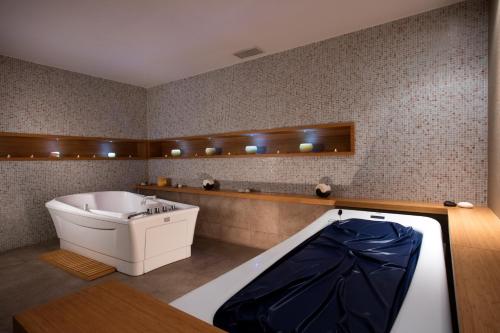 a bathroom with a tub and a sink in it at Aria Claros Beach & Spa Resort – All Inclusive 24H in Özdere