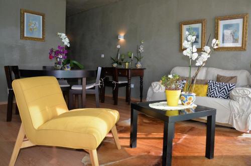 uma sala de estar com uma cadeira amarela e uma mesa em Porto Santo Balcony View House em Porto Santo